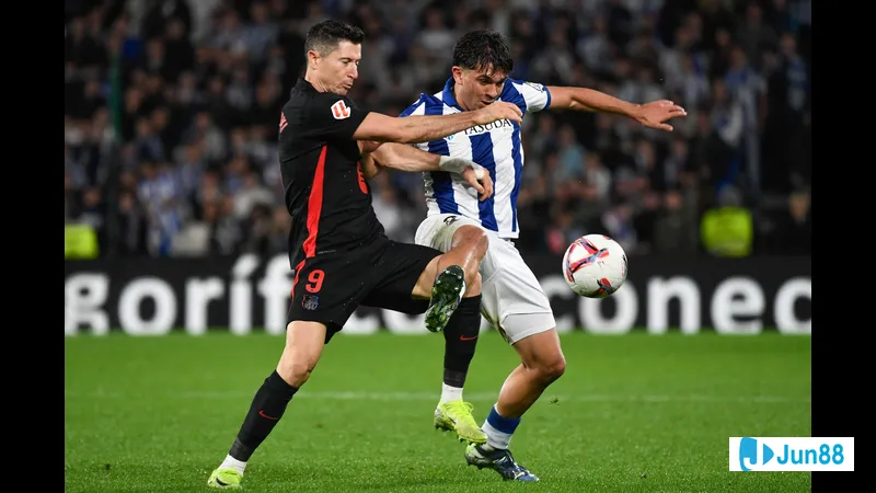 Cầu thủ Barca đi bóng qua cầu thủ của Real Sociedad trong trận đấu Cầu thủ Barca đi bóng qua cầu thủ của Real Sociedad trong trận đấu